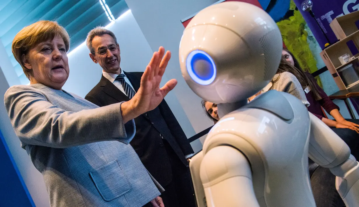 Kanselir Jerman Angela Merkel berinteraksi dengan robot interaktif di pameran Girl's Day di Berlin, Rabu (26/4). Pameran ini bertujuan menarik wanita muda untuk menggeluti pekerjaan hi-tech dan engineering. (AFP PHOTO / John MACDOUGALL)