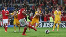 Aksi Gareth Bale saat mencetak gol kegawang Moldova pada laga kualifikasi Piala Dunia 2018 di Stadion Cardiff City Stadium, Cardif, Wales Selatan, (6/9/2016) dini hari WIB.  (AFP/Geoff Caddick)