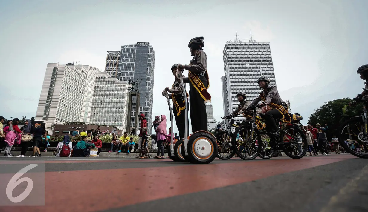 Sejumlah anggota polwan bersepeda melakukan patroli di kawasan Bunderan HI, Jakarta (15/1). Patroli menggunakan sepeda ini adalah alternatif lain dari penggunaan kendaraan bermotor saat HBKB. (Liputan6.com/Faizal Fanani)