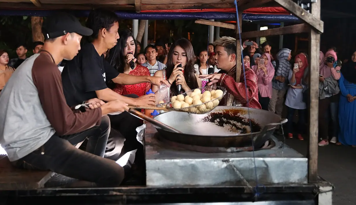 Ia menyaksikan saat Tahu Bulat tersebut masih dalam keadaan belum matang, dan juga saat proses penggorengan yang dilakukan oleh sang penjual yang duduk di atas mobil. (Bambang E. Ros/Bintang.com)
