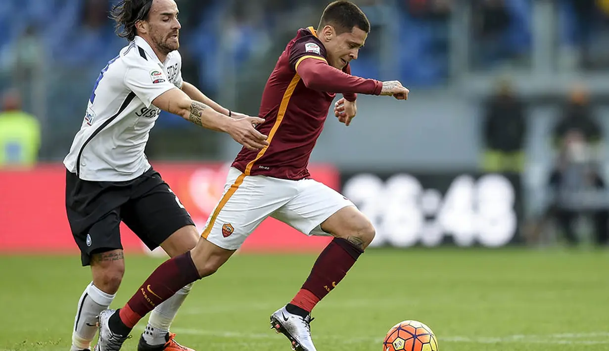 Pemain AS Roma, Juan Iturbe, berusaha melewati pemain Atalanta, Cristian Raimondi  pada laga Serie A di Stadion Olimpico, Italia, Minggu (29/11/2015). (AFP Photo/Andreas Solaro)