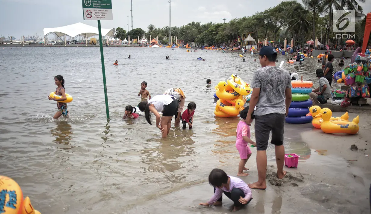 Sejumlah pengunjung bermain air di Beach Pool Ancol, Jakarta, Selasa (25/12). Pasangnya air laut dan cuaca buruk mengakibatkan pantai Ancol sepi pengunjung saat libur Natal 2018. (Liputan6.com/Faizal Fanani)