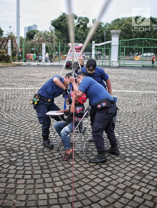 Petugas pemadam kebakaran membantu seorang anak saat mencoba wahana flying fox di area Monas, Jakarta, Selasa (1/1). Wahana ini difasilitasi oleh Dinas Pemadam Kebakaran DKI Jakarta. (Liputan6.com/Faizal Fanani)