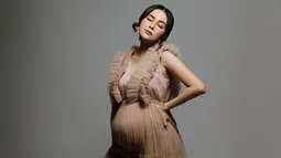 Setelah sebelumnya berpose sambil duduk, setelahnya Vicy Melanie berpose berdiri sembari menutup mata. Pencahayaan lampu yang gelap, membuat hasil foto Vicy Melanie ini estetik. Makin cantik ketika hamil, tak sedikit netizen yang memuji istri Kevin Aprilio ini. Bahkan Addie MS pun turut membubuhkan komentar pujian dan mendoakan kesehatan untuk menantu tercintanya ini. (Liputan6.com/IG/@vicymelanie)