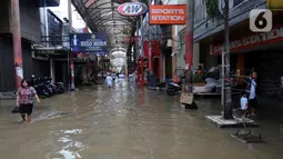 Warga melintas di kawasan pertokoan Pasar Baru, Jakarta, Kamis (2/1/2020). Pasca banjir yang melanda sejumlah titik di Jakarta pada Rabu (1/1), aktivitas perniagaan di kawasan Pasar Baru masih terlihat sepi dan sebagian toko masih tutup. (Liputan6.com/Helmi Fithriansyah)