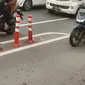 Sejumlah pengendara motor melewati jalur sepeda di Jakarta. Stick Cone pembatas jalur banyak yang rusak dan copot. (Merdeka.com)