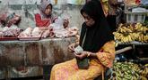 Seorang wanita menghitung uang kertas untuk membayar pembelian daging ayam di sebuah warung pinggir jalan di Jakarta pada Sabtu 8 November 2025. Pemerintah berupaya menjaga momentum agar rata-rata pertumbuhan ekonomi tahun ini bisa mencapai 5,2 persen. (YASUYOSHI CHIBA/AFP)