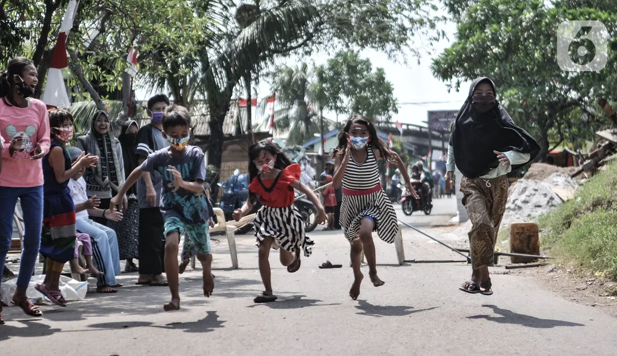 Anak-anak mengenakan masker saat mengikuti lomba memperingati HUT ke-75 RI di Kampung Nelayan, Cilincing, Jakarta, Senin (17/8/2020). Meski dilarang menggelar perlombaan akibat Covid-19, warga di Kampung Nelayan tetap mengadakan lomba 17-an walaupun hanya beberapa jenis. (merdeka.com/Iqbal Nugroho)