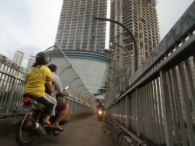 Pengendara sepeda motor melintas di atas Jembatan Penyeberangan Orang (JPO) di kawasan Grogol, Jakarta, Rabu (4/5). JPO yang seharusnya diperuntukkan bagi pejalan kaki itu kini sering dimanfaatkan pengendara motor. (Liputan6.com/Gempur M Surya)