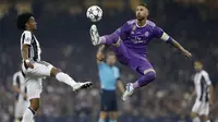 Kapten Real Madrid, Sergio Ramos, mengamankan bola dari gelandang Juventus, Juan Cuadrado, pada laga final Liga Champions di Stadion Stadion Millenium, Cardiff, Sabtu (3/6/2017). Madrid menang 4-1 atas Juventus. (AFP/Adrian Dennis)