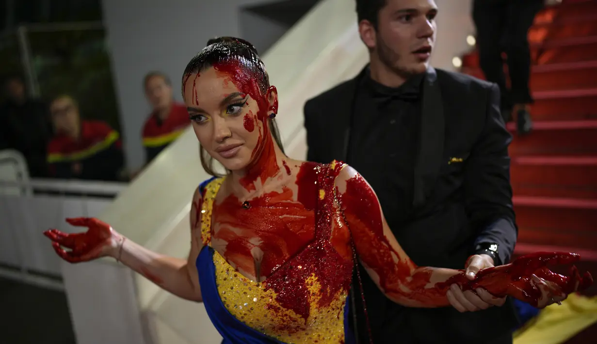 Perempuan itu muncul di karpet merah bersama A-listers dengan gaun biru dan kuning sepanjang lantai. (AP Photo/Daniel Cole)