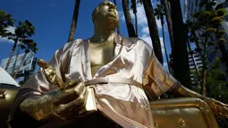 Patung Harvey Weinstein dipajang dekat lokasi ajang Piala Oscar di Hollywood, California, Kamis (1/3). Patung itu ditampilkan dalam ukuran asli dengan mengenakan jubah mandi, duduk di sofa emas sembari memegang patung piala Oscar. (AP/Damian Dovarganes)