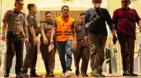 Petugas Kejati Riau menggiring terduga polisi terima suap dari bandar narkoba untuk dibawa ke Rutan Mapolda Riau. (Liputan6.com/M Syukur)