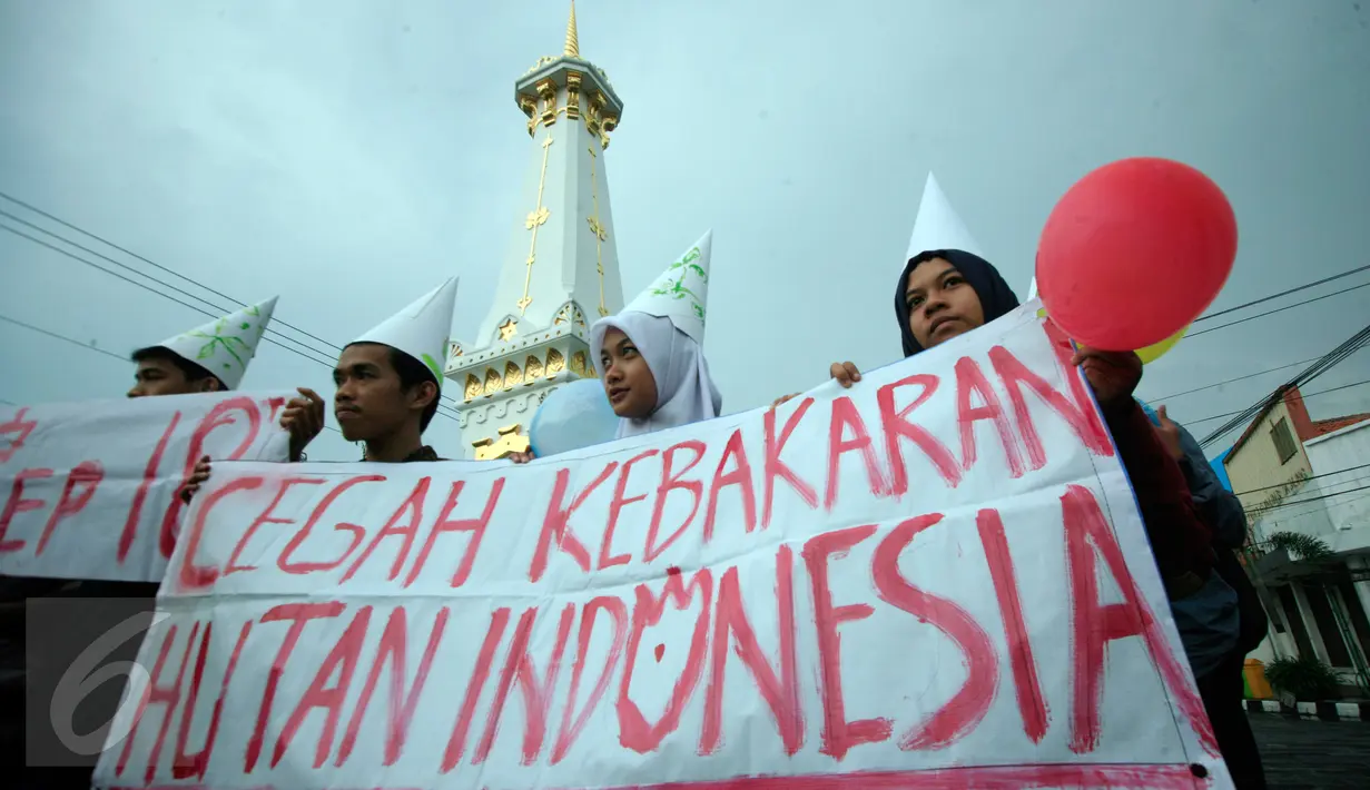 Mahasiswa membawa spanduk saat aksi peringatan Hari Hutan Dunia di Tugu ,Yogyakarta, Senin (21/3). Mahasiswa menuntut pemerintah untuk mencegah kebakaran hutan dan lahan  dan menghukum berat pelakunya. (Foto: Boy Harjanto)