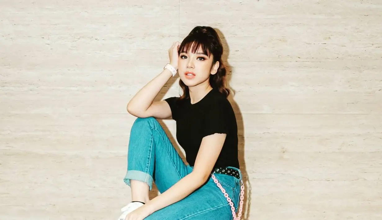 Simple tapi stylish, perempuan kelahiran 2001 ini kali ini memadukan t-shirt hitam, celana jeans, dan sneakers putih. (Instagram/tiaraandini).