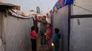 Momen tersebut menjadi ruang kecil untuk merasakan kebersamaan di tengah situasi yang belum sepenuhnya pulih. Tampak dalam foto, Para pengungsi muda Palestina memegang lampion Ramadan saat dekorasi dipasang di samping tenda mereka di kamp pengungsi Bureij di Jalur Gaza tengah pada 15 Februari 2026. (Eyad Baba/AFP)