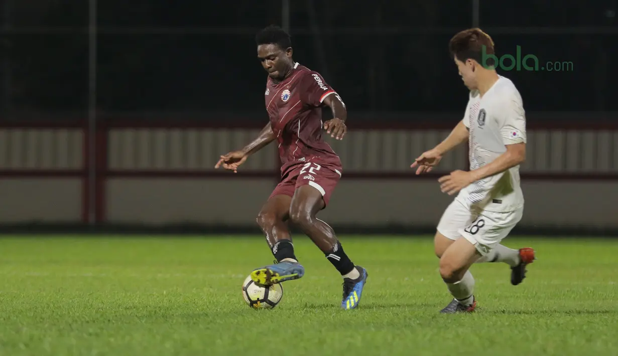 Pemain Persija Jakarta, Osas Saha (kiri) berusaha melewati adangan pemain Korea Selatan U-23 pada laga uji coba di Stadion PTIK, Jakarta, (21/6/2018). Persija kalah 1-3. (Bola.com/ Nick Hanoatubun)