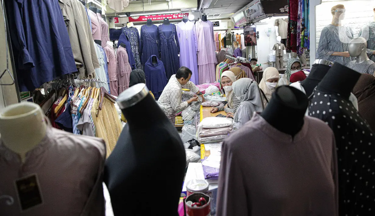 Pedagang melayani pembeli perlengkapan ibadah di Pasar Tanah Abang Blok A, Jakarta, Senin (4/4/2022). Penjualan busana muslim seperti mukena, kerudung, sajadah dan sarung mengalami peningkatan di bulan Ramadhan. (Liputan6.com/Faizal Fanani)