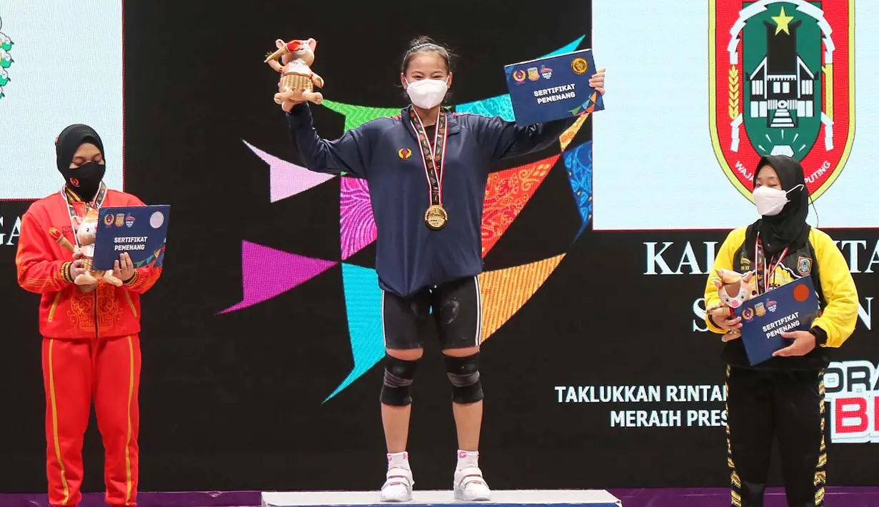 Lifter putri Jawa Barat, Windy Cantika Aisah (tengah) melakukan selebrasi di podium usai meraih medali emas kelas 49 kg dengan total angkatan 192 kg. (Foto: PB PON XX PAPUA/Dadang Tri)