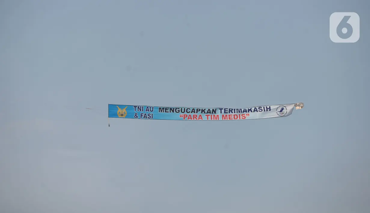 Anggota FASI, organisasi ordirga berbasis komunitas binaan TNI AU, menerbangkan pesawat Microlight Trike yang membawa spanduk “Terimakasih pada Tim Medis COVID-19” di kawasan RS darurat penanganan Covid-19 Wisma Atlet Kemayoran, Jakarta, Sabtu (20/6/2020). (merdeka.com/Iqbal S Nugroho)