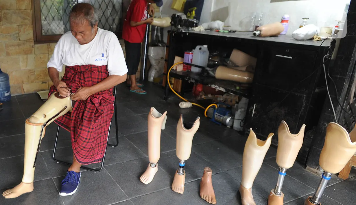 Penyandang disabilitas memasang kaki palsu di sebuah bengkel kawasan Ciputat Baru, Tangerang Selatan, Banten, Senin (14/10/2019). Kaki dan tangan palsu tersebut dijual dengan harga Rp 5 juta hingga Rp 50 juta. (merdeka.com/Arie Basuki)