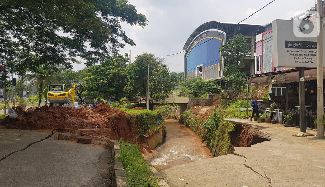 Jalan ambles di ruas Jalan Boulevard, Grand Depok City (GDC), Kota Depok, Jawa Barat, Selasa (13/4/2021). Jalan tersebut ambles ke aliran sungai sedalam 3 hingga 5 meter. (Liputan6.com/Herman Zakharia)