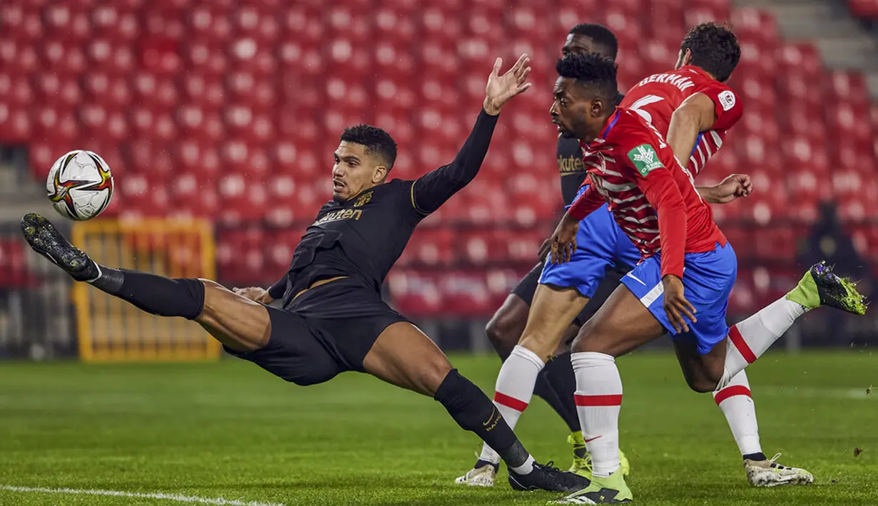 Pemain Barcelona Ronald Araujo (kiri) mencoba untuk menendang bola saat melawan Granada pada pertandingan perempat final Copa del Rey di Stadion Los Carmenes, Granada, Spanyol, Rabu (3/2/2021). Barcelona sukses kalahkan Granada 5-3 dan mendapatkan tiket semifinal Copa del Rey. (AP Photo)