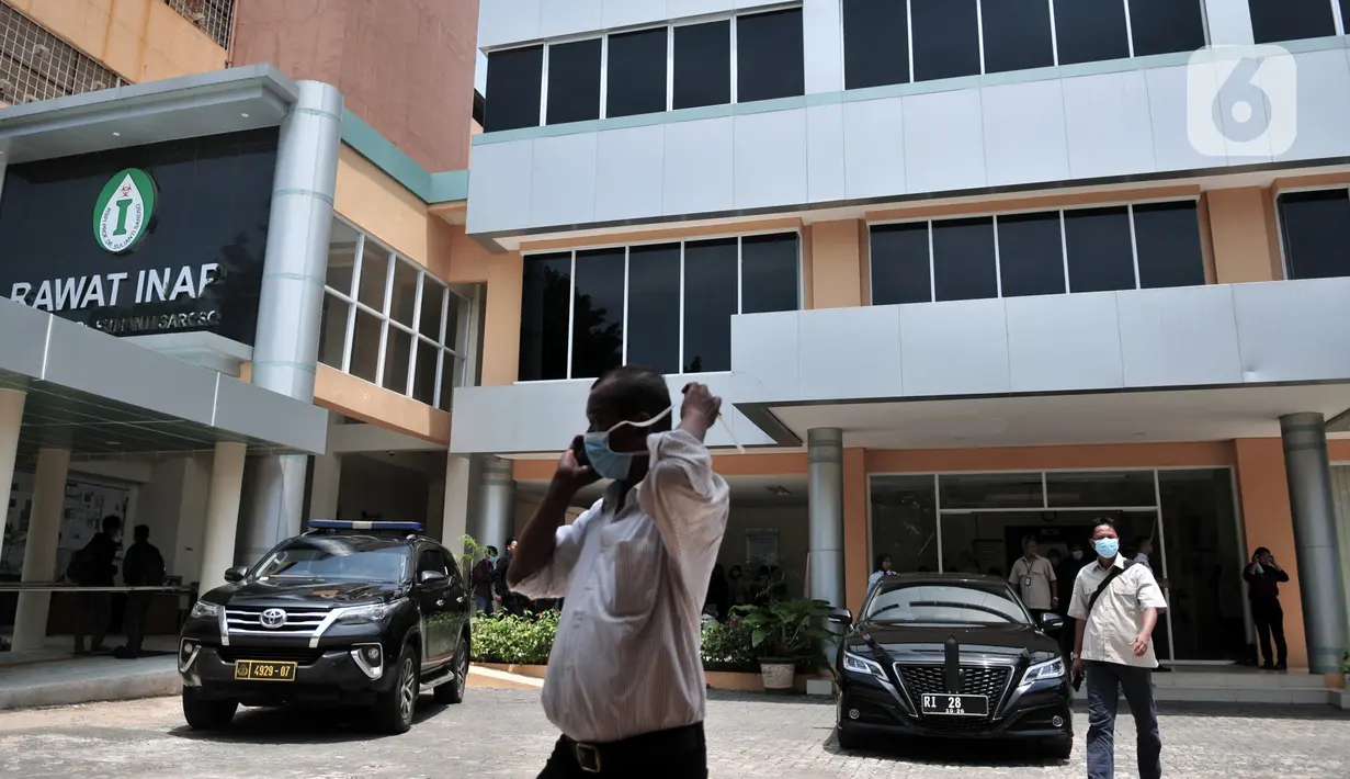 Pengunjung mengenakan masker melintasi kendaraan dinas Menteri Kesehatan RI saat menjenguk pasien positif Corona di RSPI Prof. DR. Saroso, Sunter, Jakarta, Senin (2/3/2020). (merdeka.com/Iqbal S. Nugroho)