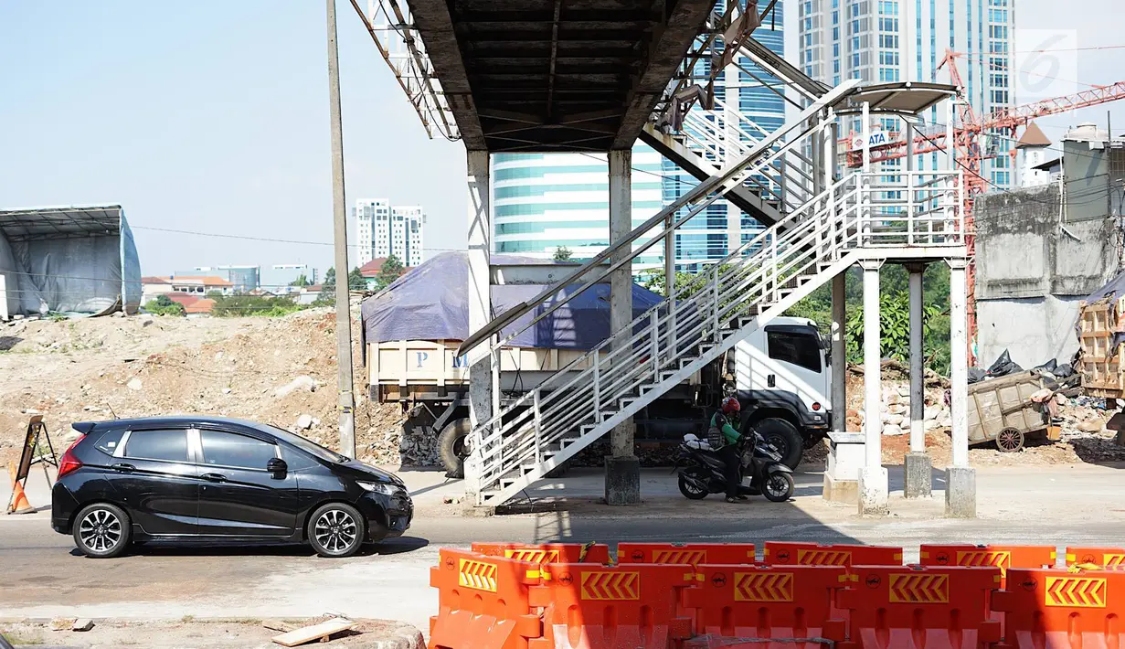 Kendaraan melintas di samping tangga akses JPO di Jalan Antasari, Jakarta, Jumat (24/5/2019). Proyek pelebaran jalan yang tidak dibarengi dengan pemanjangan JPO menyebabkan akses tangga JPO tersebut berada di tengah jalan. (Liputan6.com/Immanuel Antonius)