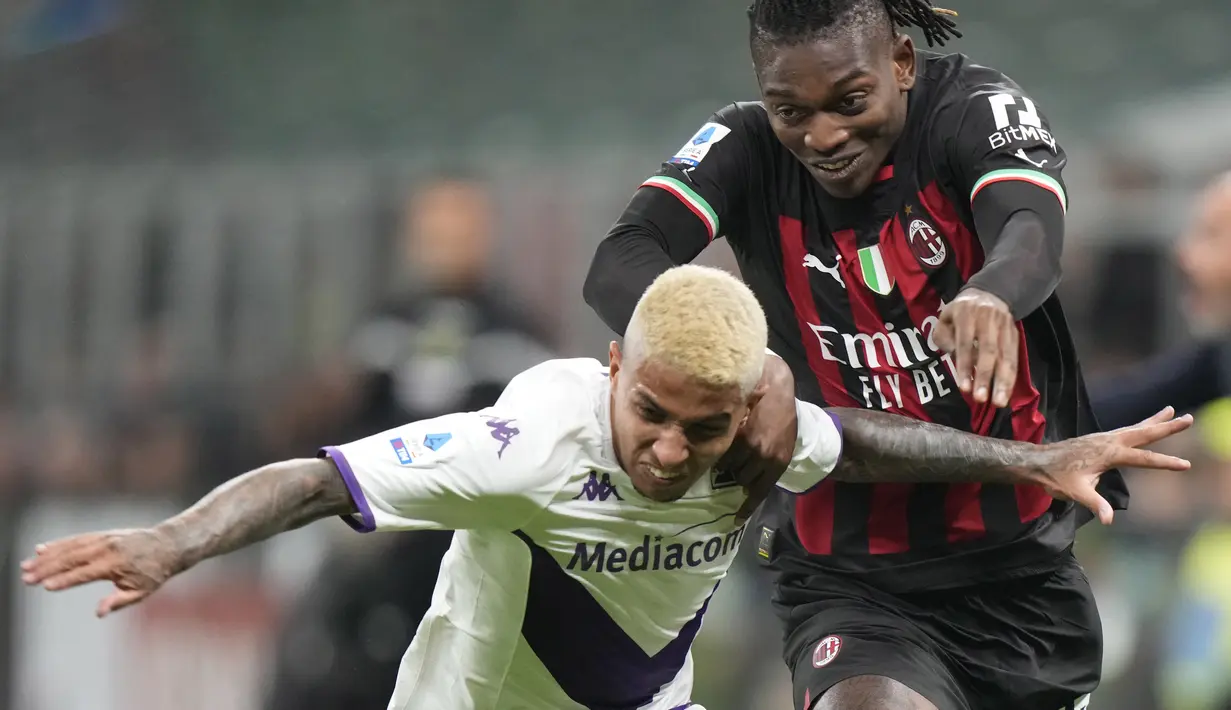 Penyerang AC Milan Rafael Leao berebut bola dengan pemain Fiorentina Dodo pada duel pekan ke-15 Serie A 2022/2023 di San Siro, Senin (14/11/2022). Kemenangan ini penting bagi Milan untuk terus mengejar Napoli di puncak klasemen sementara Serie A 2022/23. (AP Photo/Luca Bruno)