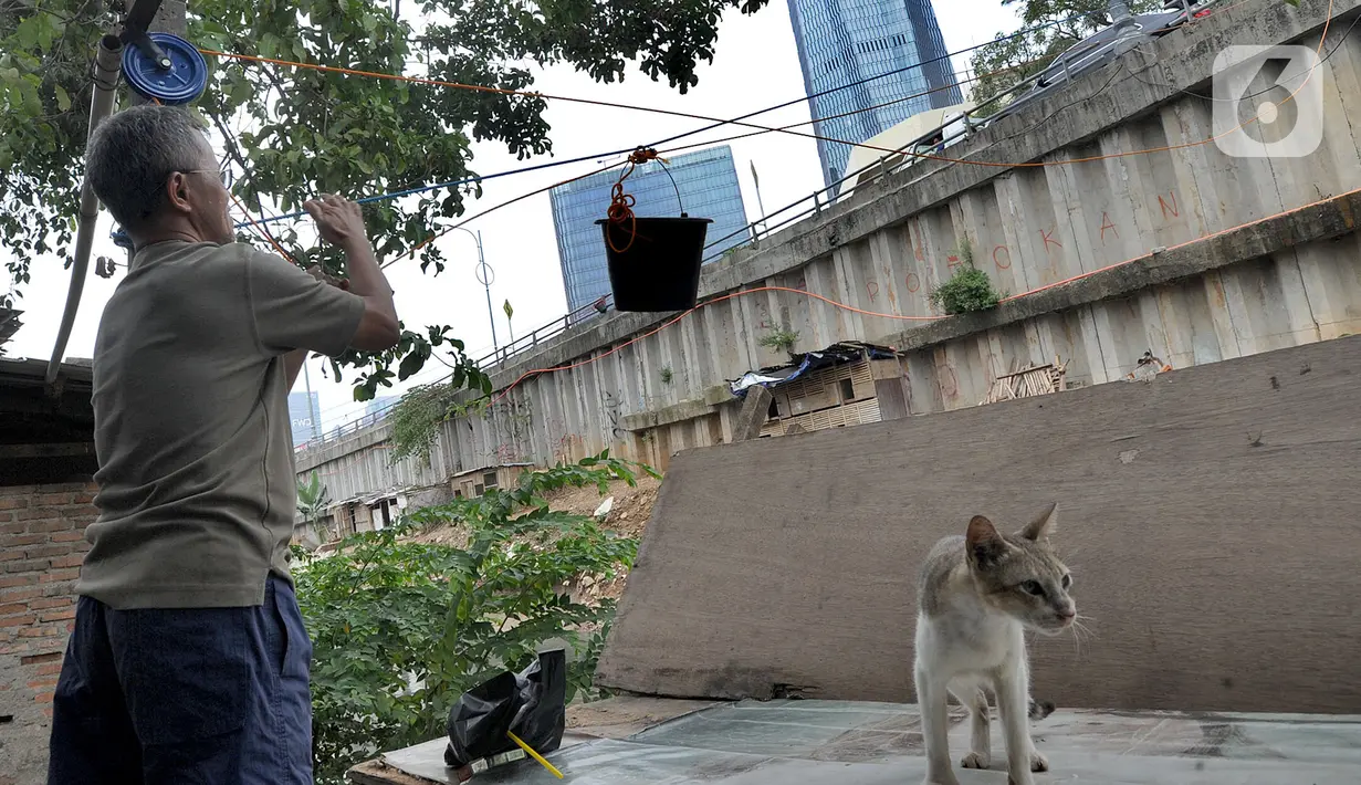 Namun sejak jembatan tersebut diambil kembali oleh pemilik proyek gedung, warga akhirnya menarik ember yang tergantung pada tali untuk melayani pembeli. (merdeka.com/Arie Basuki)