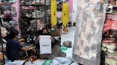 Pekerja membungkus baju muslim pesanan secara online di home industri busana muslim Albarizk UMMA di kawasan Beji, Depok, Selasa (12/4/2022). Mendekati lebaran, penjualan jilbab dan busana musim secara online meningkat 100 persen dibandingkan tahun lalu saat masa pandemi. (merdeka.com/Arie Basuki)