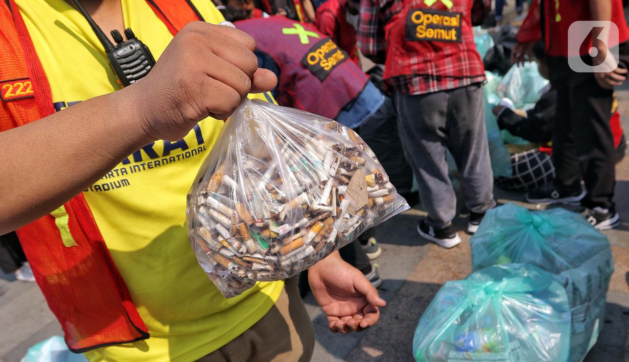 Pegiat lingkungan menunjukkan sebungkus puntung rokok yang dikumpulkan saat mengumpulkan sampah pada Hari Bebas Kendaraan Bermotor (HKBP) atau Car Free Day (CFD) di kawasan Bundaran HI, Jakarta, Minggu (29/10/2023). Kegiatan ini sebagai bentuk kampanye untuk mengajak warga agar peduli terhadap lingkungan dengan cara mengurangi penggunaan plastik. (Liputan6.com/Angga Yuniar)