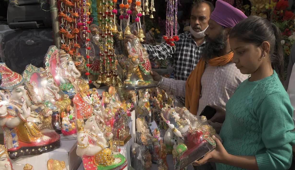 Orang-orang membeli patung dewa Hindu menjelang festival Diwali di sebuah pasar di Amritsar, India pada 10 November 2020. Tahun ini festival lampu Diwali jatuh pada 14 November mendatang. (Photo by NARINDER NANU / AFP)