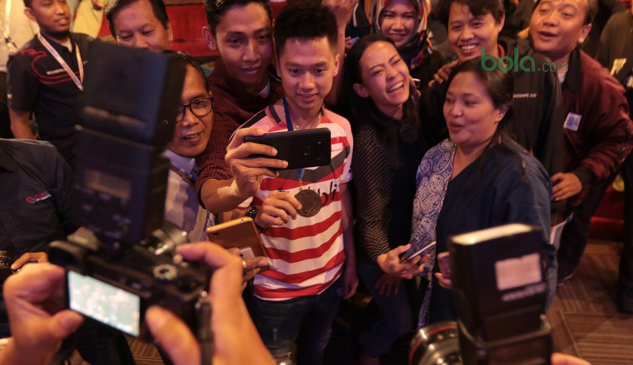 Kevin Sanjaya mengikuti foto elfie bersama fans dan wartawan di Galeri Indonesia Kaya, Grand Indonesia, Jakarta (28/3/2018). Kevin menerima deposito sebesar Rp 200 juta. (Bola.com/Nick Hanoatubun)