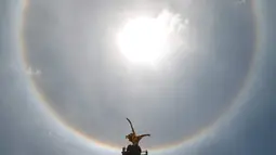 Fenomena halo matahari dengan latar depan monumen Malaikat Kemerdekaan di pusat kota Mexico City, Sabtu (7/7). Fenomena halo matahari terjadi karena pembiasan kristal es yang berada di sekitar Matahari yang membentuk semacam pelangi. (AP/Anthony Vazquez)