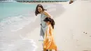 Bermain di pantai, keduanya mengenakan dress warna bright yang membuat mereka berdua nampak ceria.   Credit: Instagram/(@gisel_la)