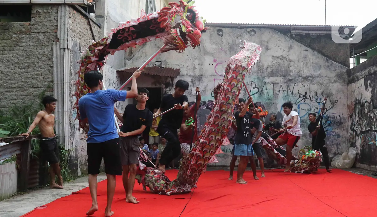 Pemain dari kelompok barongsai Naga Merah Putih Bogor melakukan latihan dengan Liong di kawasan Babakan Pasar, Kota Bogor, Jawa Barat, Rabu (11/1/2023). Latihan tersebut  untuk mempersiapkan penampilan menyambut Tahun Baru Imlek. (Liputan6.com/Herman Zakharia)