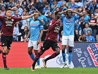 Ekspresi pemain Napoli, Victor Osimhen (kanan) setelah pemain Salernitana, Boulaye Dia (tengah), mencetak gol penyeimbang di menit ke-84 dan membuat skor menjadi 1-1 dalam pertandingan lanjutan pekan ke-32 yang berlangsung di Stadion Diego Armando Maradona, Minggu (30/4/2023). (AFP/Filippo Monteforte)