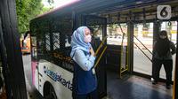 Seorang petugas layanan bus Transjakarta khusus wanita menunggu penumpangg di kawasan Pasar Baru, Jakarta, Rabu (27/7/2022). Pelayanan bus pink ini merupakan salah satu upaya Transjakarta ikut menangani masalah pelecehan dalam transportasi publik. (Liputan6.com/Faizal Fanani)