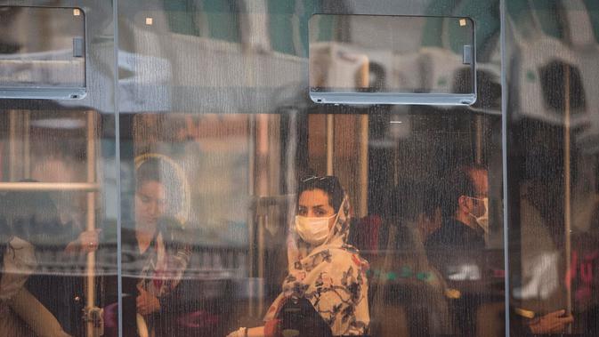Seorang wanita dengan masker menaiki bus di pusat Kota Teheran, 28 Juni 2020. Presiden Iran Hassan Rouhani pada Minggu (28/6) mengatakan mengenakan masker di tempat umum akan menjadi wajib mulai pekan depan di tengah meningkatnya kasus dan kematian akibat COVID-19. (Xinhua/Ahmad Halabisaz)