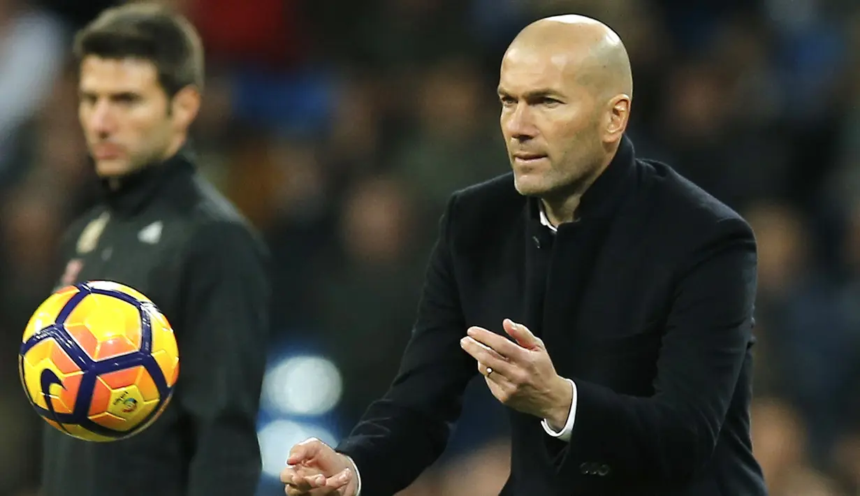 Pelatih Real Madrid, Zinedine Zidane melempar bola ke dalam lapangan saat timnya sedang ketinggalan melawan Las Palmas pada lanjutan La Liga Spanyol di Santiago Bernabeu stadium, Madrid, (1/3/2017). Madrid bermain imbang 3-3.  (AP/Paul White)