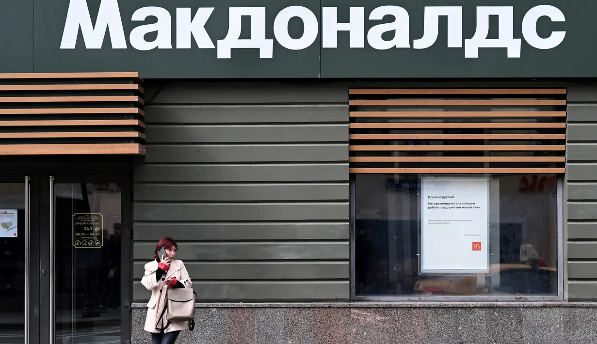 Seorang perempuan berbicara melalui ponsel di depan restoran McDonald's yang tutup di Moskow, Rusia pada 16 Mei 2022. Raksasa makanan cepat saji asal Amerika, McDonald's, akan keluar dari pasar Rusia dan menjual bisnisnya di negara yang semakin terisolasi itu, kata perusahaan tersebut pada Senin kemarin. Banyak bisnis Barat menarik diri dari Rusia sejak invasi pasukan Moskwa ke Ukraina pada Februari. (Kirill KUDRYAVTSEV / AFP)