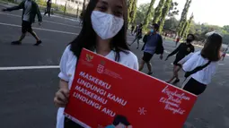 Seorang wanita saat mengkampanyekan Gerakan Masker Nasional "Jangan Kendor, Disiplin Pakai Masker" di Gelora Bung Karno, Jakarta (30/8/2020). Pembagian masker dan kampanye ini dilakukan mengantisipasi penyebaran lebih luas lagi virus covid-19. (Liputan6.com/Johan Tallo)