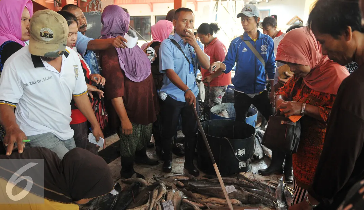Sejumlah pembeli memilih ikan hiu di tempat pelelangan ikan Karangsong, Indramayu, Jawa Barat, Kamis (16/6/2015). Ikan hiu seperti hiu lontar, hiu cucut, hiu martil dijual seharga Rp. 25 ribu - Rp. 50 ribu per kilogram. (Liputan6.com/Herman Zakharia)