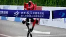 Namun, pada lomba tahun ini, peningkatan performa terlihat jelas dengan sejumlah robot mampu berlari stabil dan bersaing ketat. Tampak dalam foto, sebuah robot melintasi garis finis dalam ajang Beijing E-Town Half Marathon dan Humanoid Robot Half-Marathon yang diadakan di pinggiran Beijing, Minggu 19 April 2026. (AP Photo/Andy Wong)