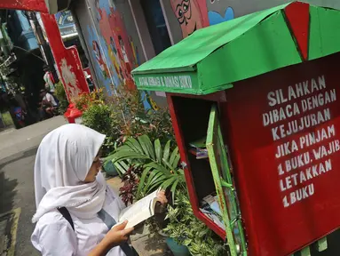 Seorang pelajar membaca buku di Kampung Literasi RW 08, Jatipulo, Palmerah, Jakarta Barat, Kamis (30/1/2020). Kampung Literasi ini memiliki 5 kotak berisi beragam buku yang ada di sejumlah titik, berbekal konsep kejujuran disebar di sepanjang kampung. (Liputan6.com/Herman Zakharia)