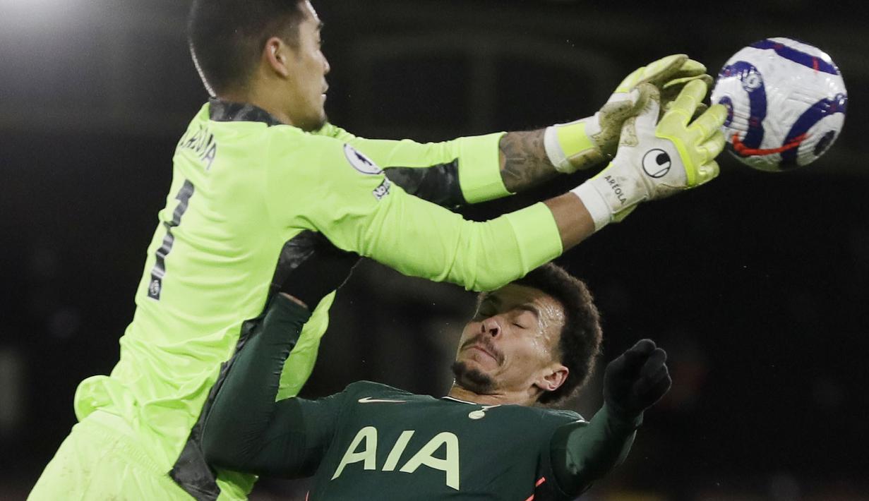 Penyerang Tottenham Hotspur, Dele Alli, duel udara dengan kiper Fulham, Alphonse Areola, pada laga Liga Inggris di Stadion Craven Cottage, Kamis (4/3/2021). Tottenham Hotspur menang dengan skor 1-0. (Neil Hall/Pool via AP)