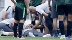 Dokter Timnas Indonesia, Syarif Alwi, memeriksa Danurwindo, yang pingsan usai memantau latihan di Stadion Wibawa Mukti, Jawa Barat, Sabtu (03/11/2018). Danurwindo ambruk ketika tim dan ofisial melakukan sesi foto bersama. (Bola.com/M Iqbal Ichsan)