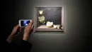 Seorang pengunjung mengambil gambar lukisan Quince, Cabbage, Melon and Cucumber (1602) karya pelukis Spanyol Juan Sanchez Cotan (1560-1627) saat pameran 'Spanish Still Life' di Pusat Seni Rupa BOZAR, Brussels, Belgia, Jumat (22/2). (AFP PHOTO/JOHN THYS)